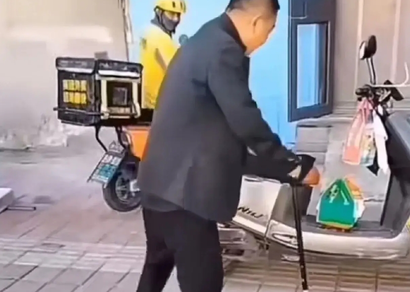 一位老人看到一辆无人的外卖电动车，外卖员应该是去送外卖了，老人直接拿了外卖就想离