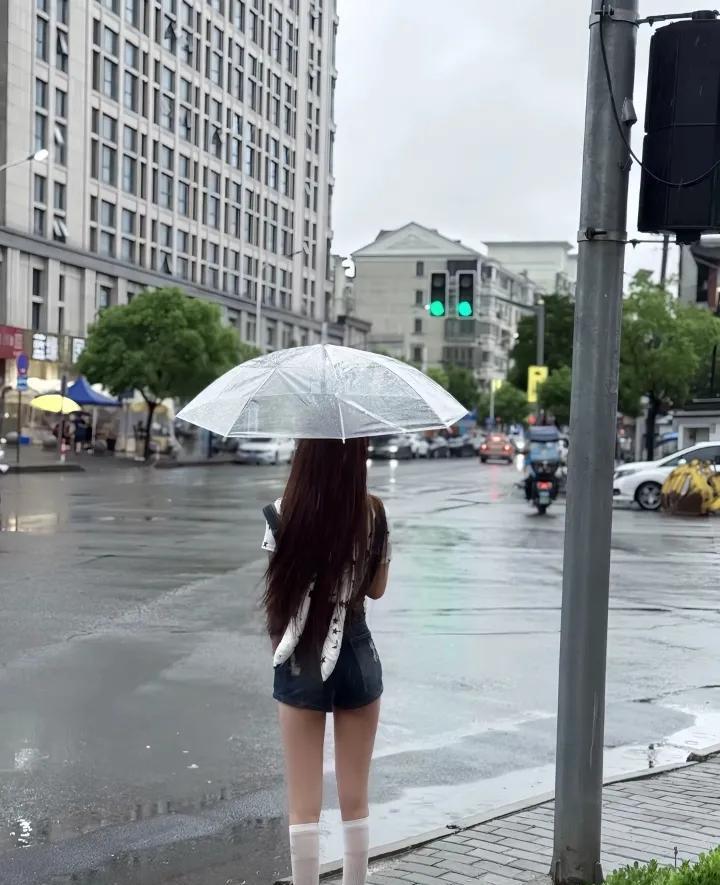 姐妹儿，你是在这儿等雨停呢，还是琢磨这水坑能不能比自己鞋底深[泪奔]？
这下雨天