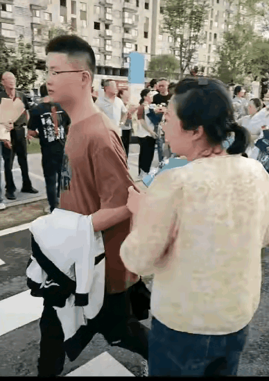孩子刚出考场后，妈妈激动地手捧一束鲜花，迎接儿子的到来，没料到儿子却冷着脸，转身