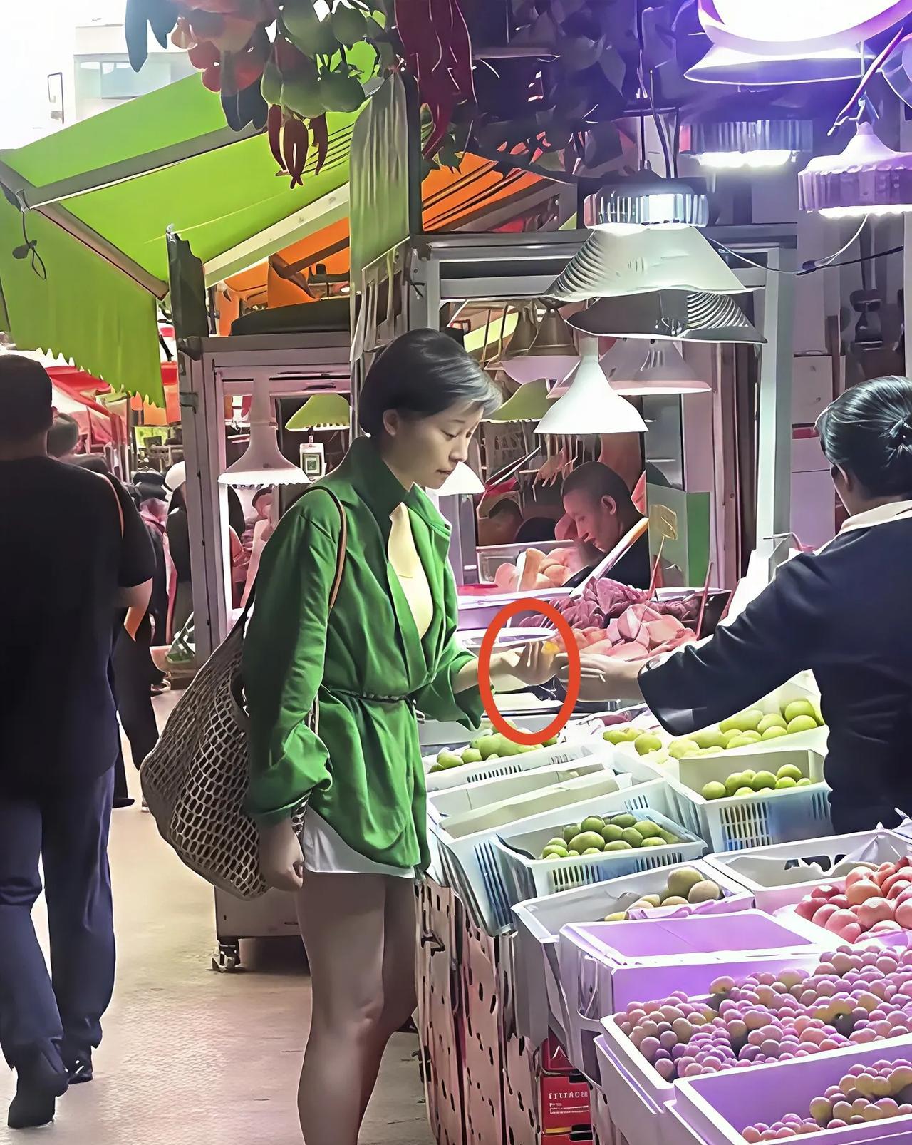 谁能想到，
刚捧回影后奖杯的吴越，
此刻正捏着水果在菜市场讨价还价？
没有墨镜口