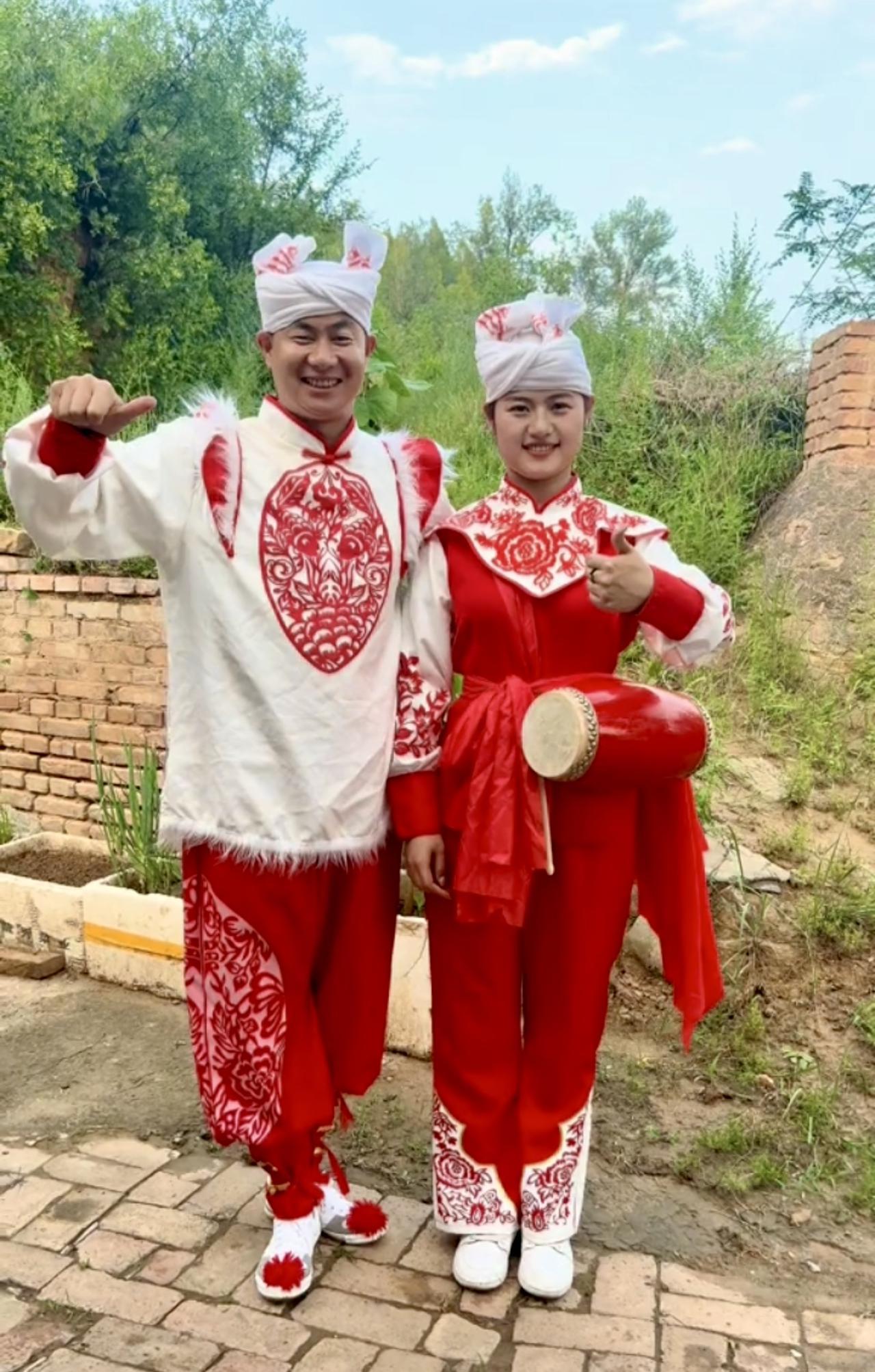 七律·腰鼓装
白帕缠头意态昂，红装绣彩韵悠长。
鼓悬腰际情难捺，花绽衣间兴欲狂。