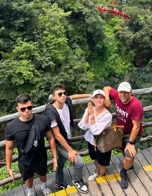 看她发旅游时拍下的全家福，一家子都是大高个，还都是高颜值！
她是巩俐的同班同学，