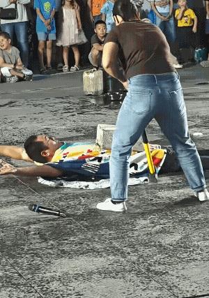 坏了，胸口碎大石出现失误，大铁锤砸到了胸口。
躺在地上的男子肚子上放了一块四方块