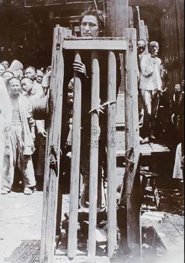 这是1900年上海一名犯人受刑的照片，看起来很普通，就是一个人站在笼子里，但其实