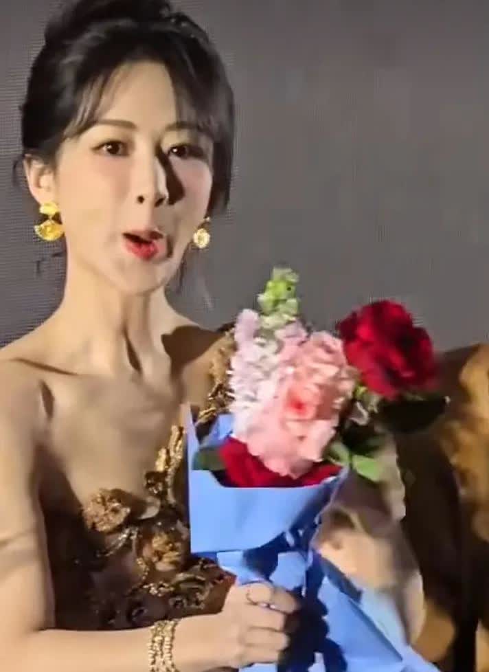 不懂就问，为什么要这样笑？

某活动现场，杨紫俯身整理桌面上的鲜花，粉丝们在