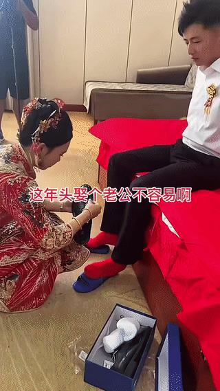 新娘子亲自为入赘她家的新郎穿鞋穿袜。
看起来真是非常的细心。
虽然新郎是“上门女