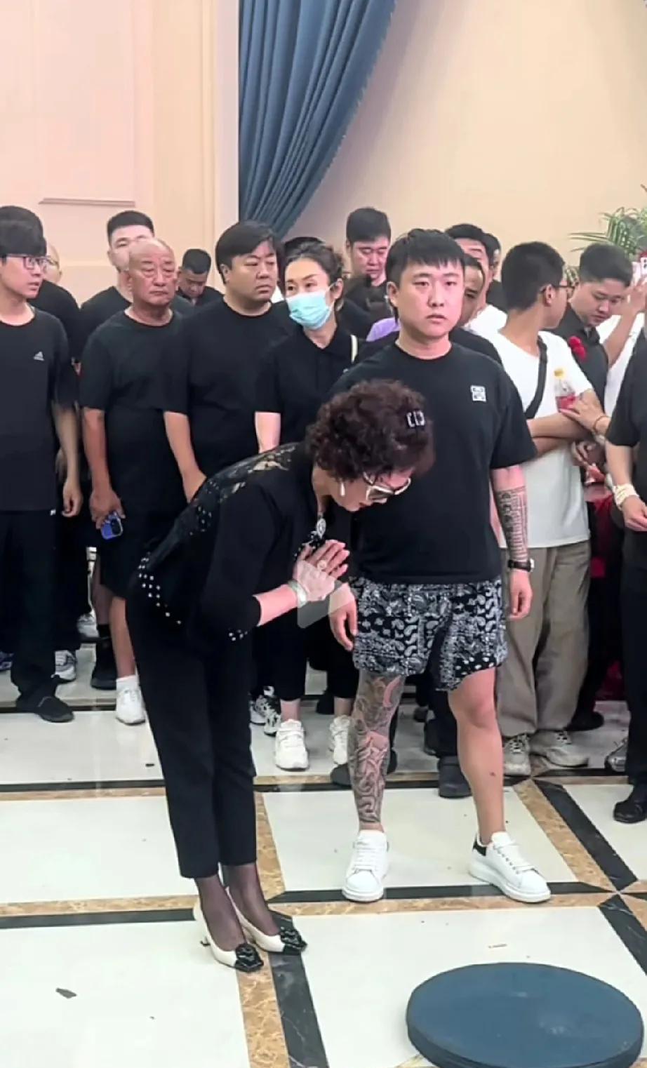 老五婶儿梦真也来吊唁了。
穿了一身黑西装，非常正式，还和家属亲热的拥抱。毕竟和杨
