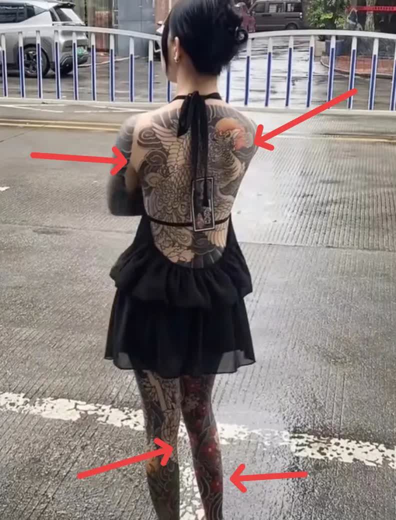 广东，一女孩全身都纹满了纹身，从脖颈到脚踝，全都纹上了各式各样的图案，路过的行人