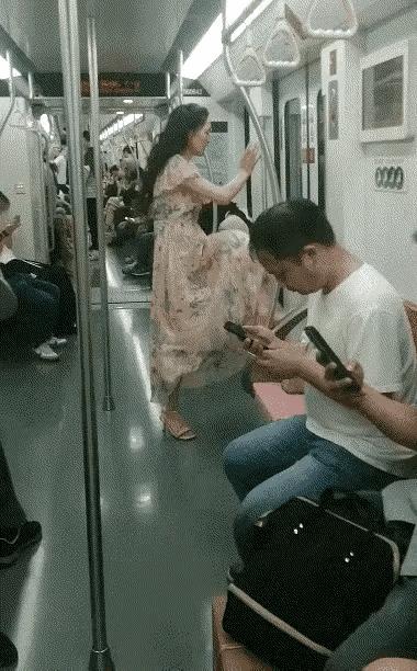 大妈在地铁里旁若无人般肆意扭动着身体 ，完全不在意这里是公共场所，完全不在意打扰
