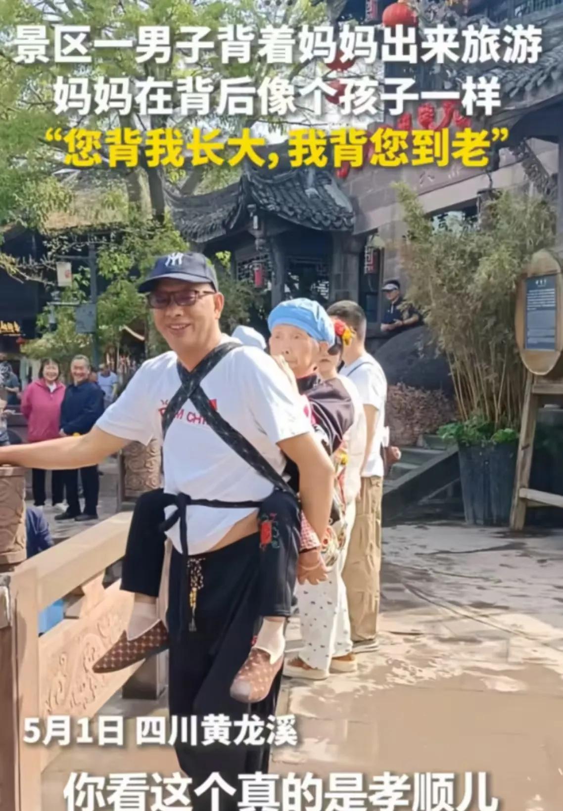 “您背我长大， 我背您到老！”四川黄龙溪，男子背着年迈的母亲出游，犹如一个行走的