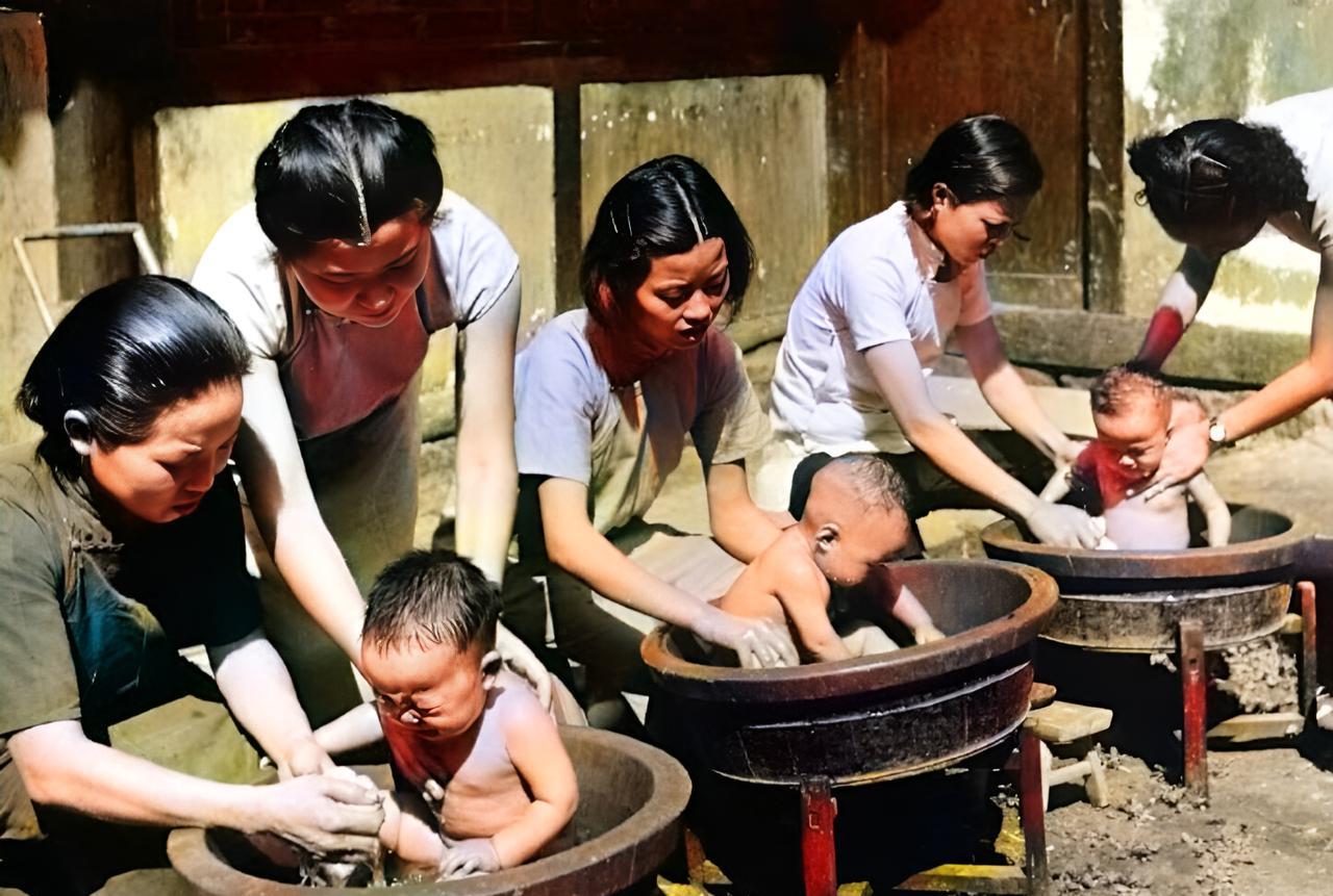 这张照片拍摄于1941年。几名梳着短发，穿着短袖旗袍的女子忙着为三个孩子洗澡。孩