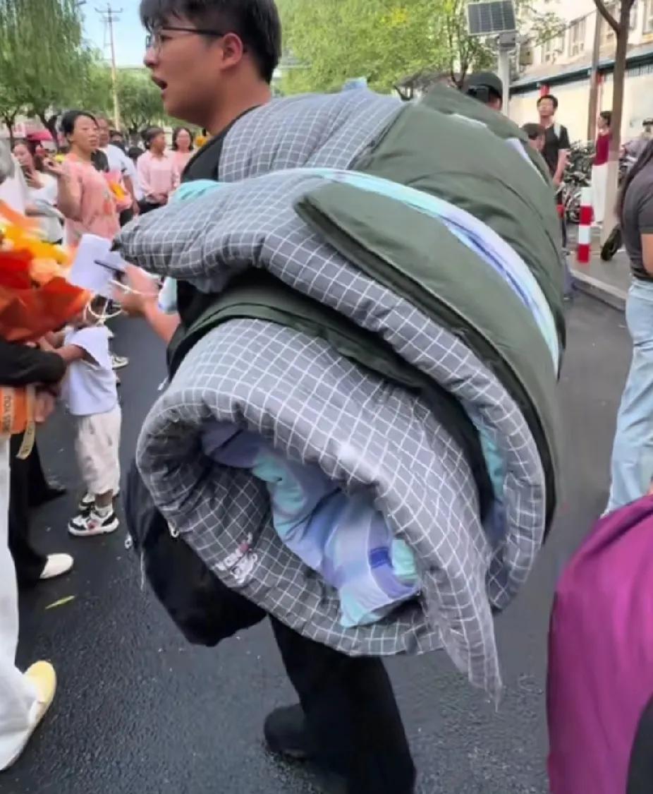 高考结束后，男孩回到自己的学校，当看到男孩出来时，背上背着的东西，让人直呼这孩子