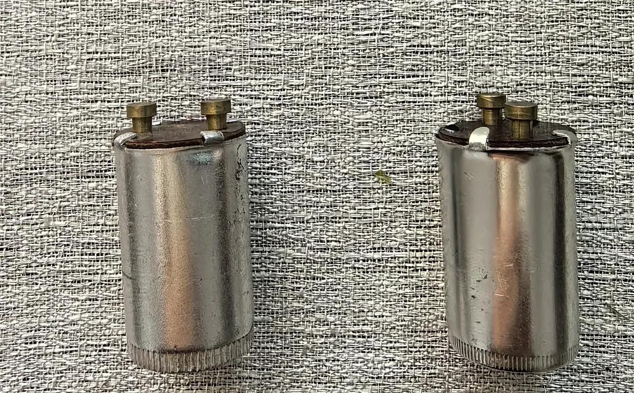 收拾家当，翻出俩铝制小玩意儿。瞧这模样，金属外壳，顶端还有几个小部件。它们是啥？