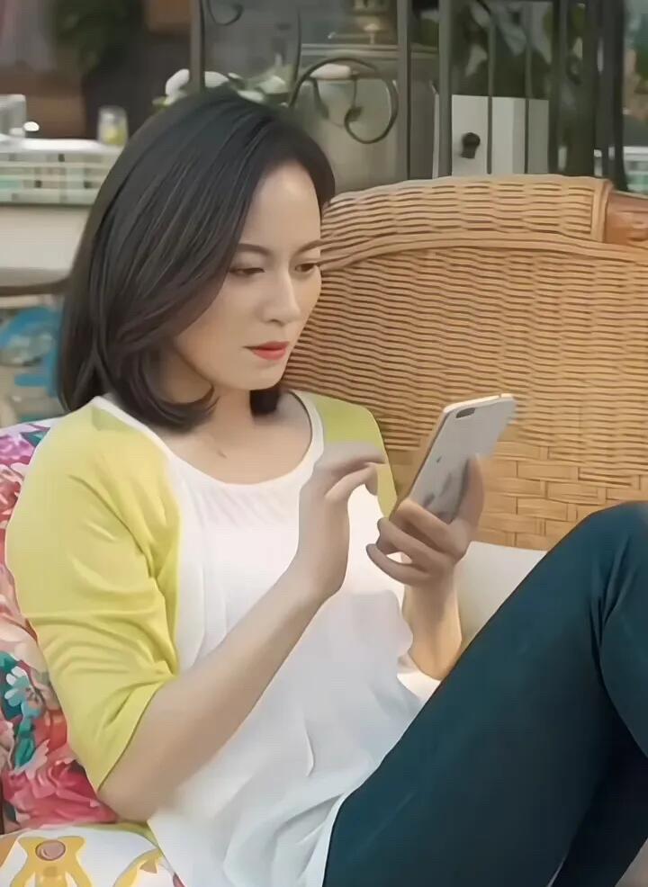 难得一见俞飞鸿一身休闲装打扮在家悠闲的情景，她一个人看着手机，年轻的时候她可是观