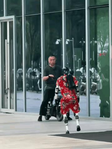 男子骑车偶遇一个穿着碎花大红裙子的机器人拦住去路，男子吓的停下车，一脸懵逼的盯着