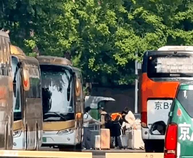 多哈回国的那一天，大家一起坐大巴回到体育总局。

隔着车窗瞄到王楚钦推着两个