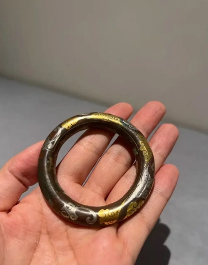 昨天帮老丈人挖蒜苗子捡到个铜环环，上面镶嵌着金银和云纹。我打算拿回家送给老婆当手