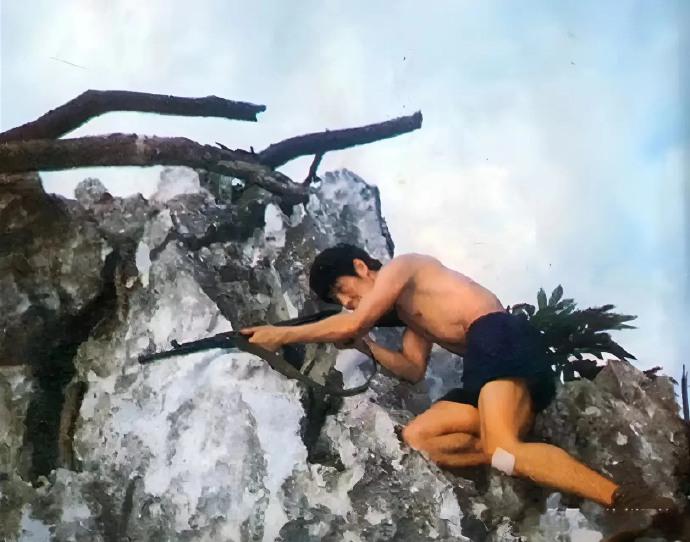 80年代的中越边境上，一位解放军战士坚守在一个岩石上。

照片中这位解放军战士叫
