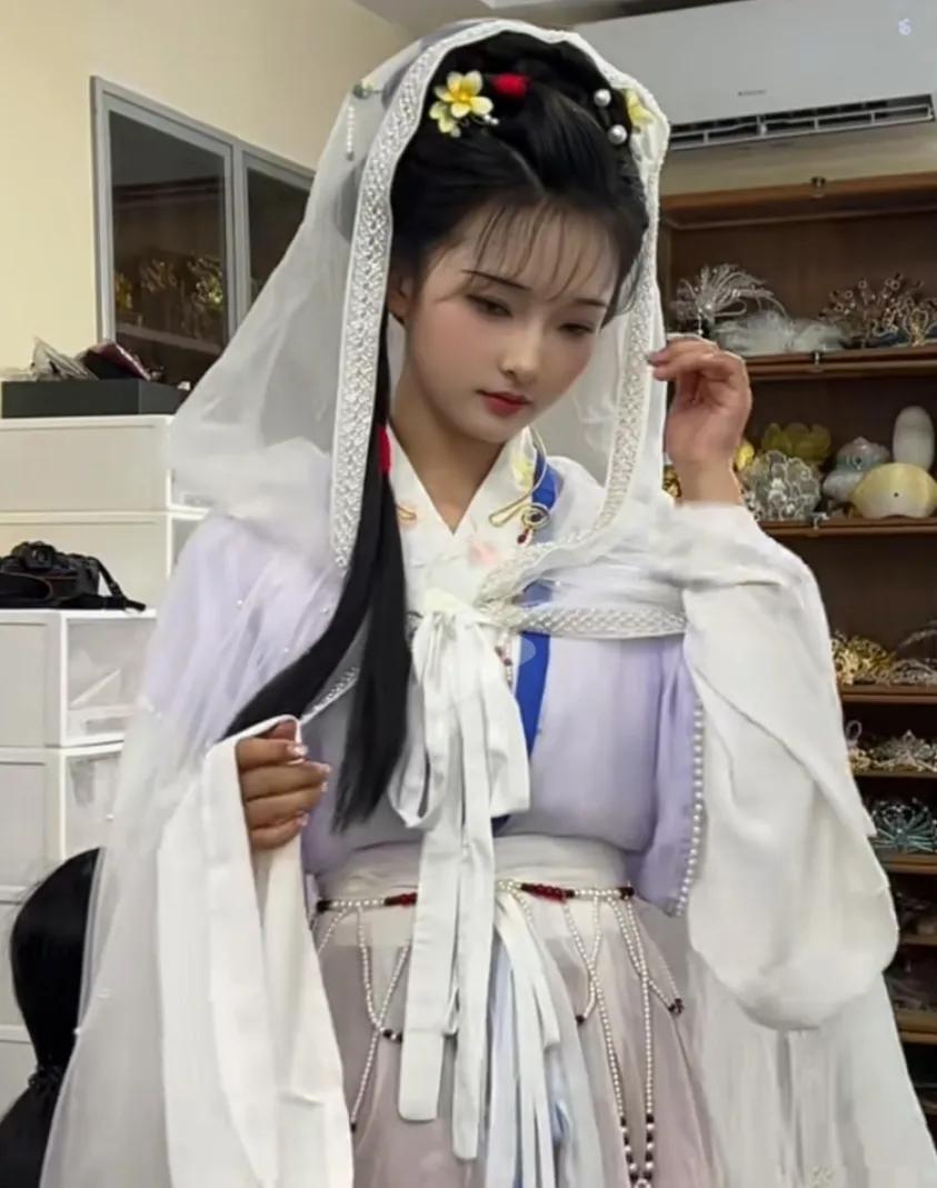 《观汉服佳人》
粉裳轻裹玉容娇，翠鬓簪花韵自饶。
恰似仙娥临俗世，一帘风动月中绡
