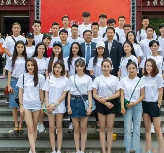 这是上海戏剧学院表演系的一张照片。 女同学站前两排，几个老师站中间，男学生站后面