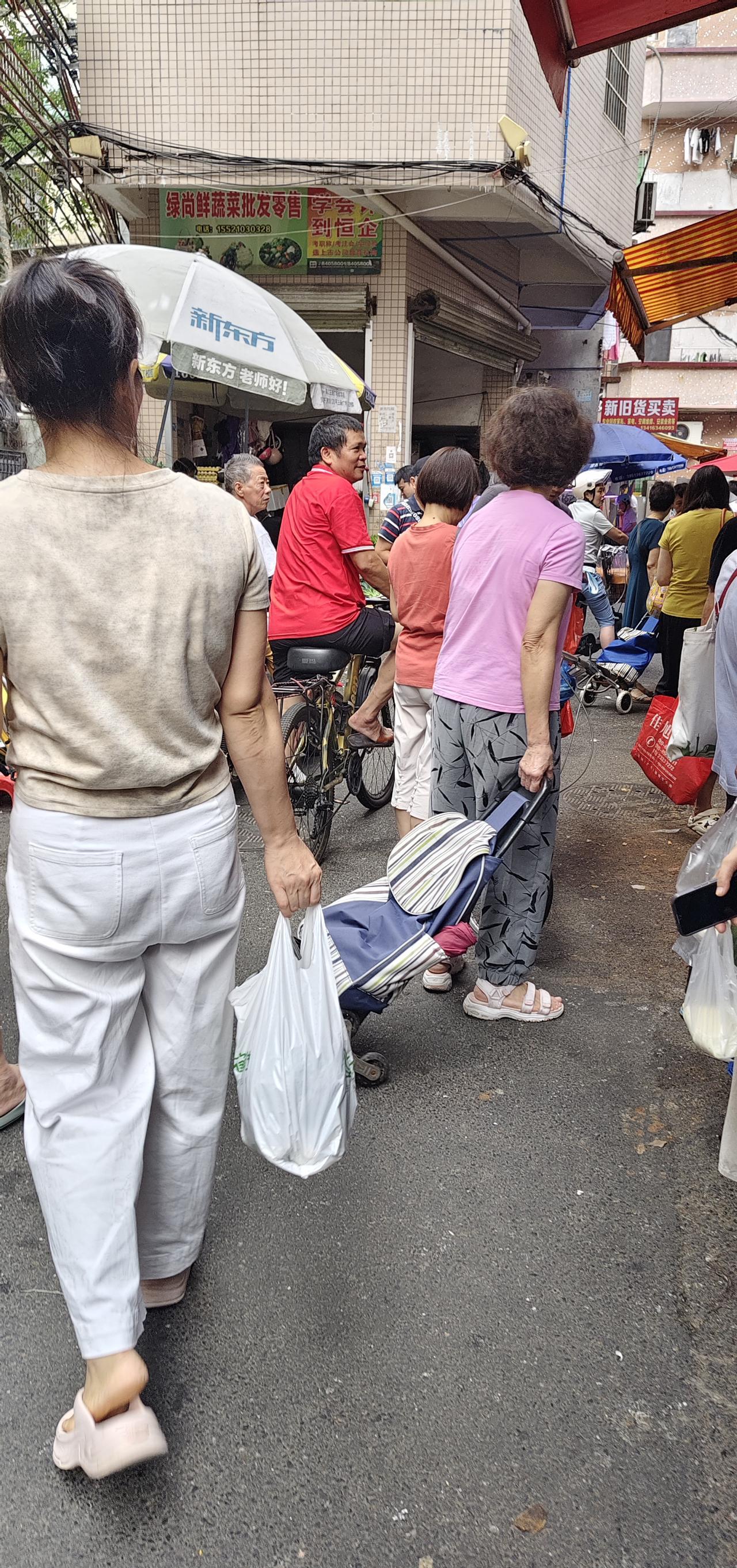 今早，去买菜，发现一个算命的人。
这里不是菜市场，是一条街巷子，买菜的人（如图）