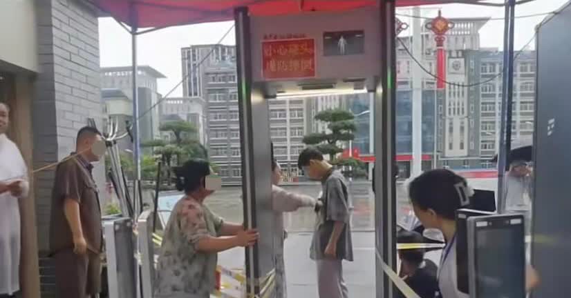 看到这样的场面，感觉如鲠在喉...
学生因衣服有金属进不去，陌生大叔二话不说把
