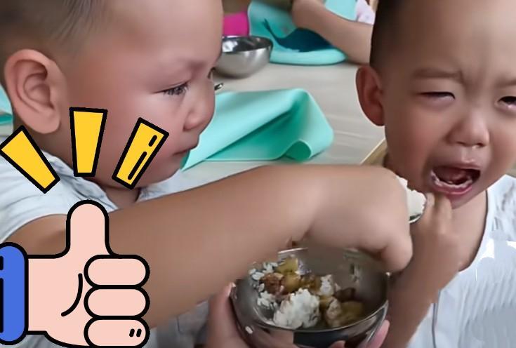 才入幼儿园的小男孩，刚开始神情自若，看到邻座的小伙伴不吃饭哭着要妈妈，他就像一个