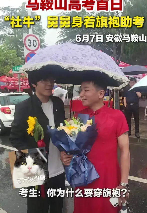 高考考场外面，男子穿了一身红色旗袍，抱着鲜花，打着蕾丝边雨伞等待着。
考生走出考