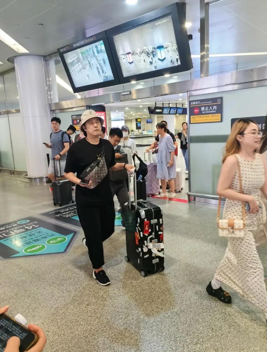 50岁的演员冯雷现身萧山机场，戴着渔夫帽，穿着一身黑色，个子挺高，脸很胖，眼睛很