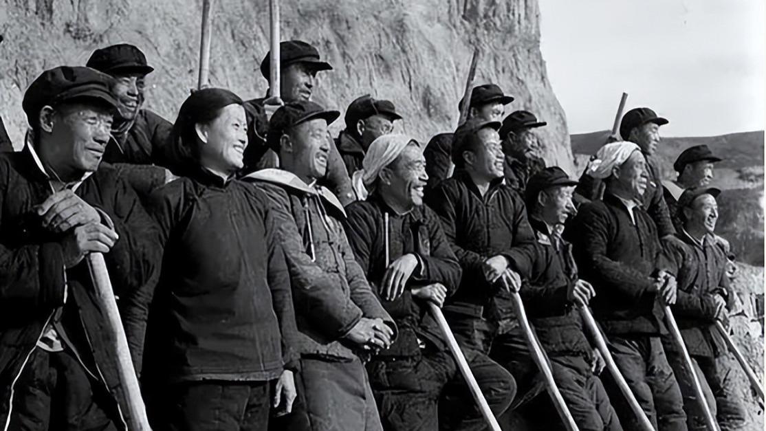 两排农民拿着撅头的老照片，为何如此出名？只因其中有一个大人物