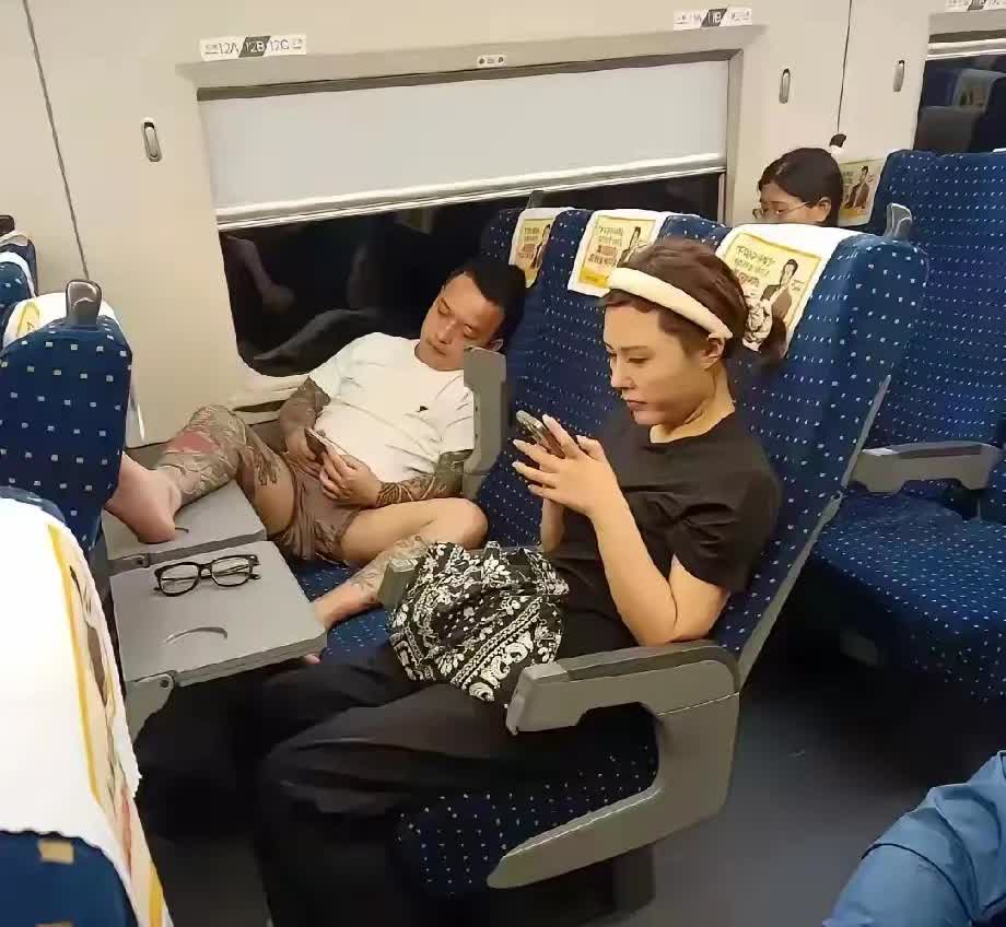 请看这位，公然在高铁上叉开双腿，恨不得把那只纹得色彩斑斓的腿脚伸到邻座女孩面前。