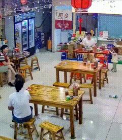 婆媳因小事发生争执，丈夫坐在饭店中间的位置沉默不语，儿媳拍着桌子，指着丈夫说：“