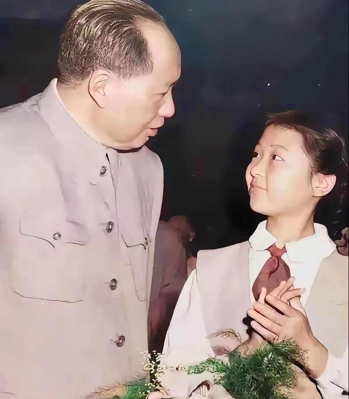 伟大领袖毛主席和少先队员合影，照片中女少先队员向毛主席献花。
毛主席像长辈一样亲