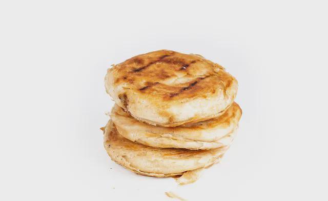 街边有家烧饼摊。
每个烧饼售价两元，五个十元。
那天，我买了十元的，她却只给了五