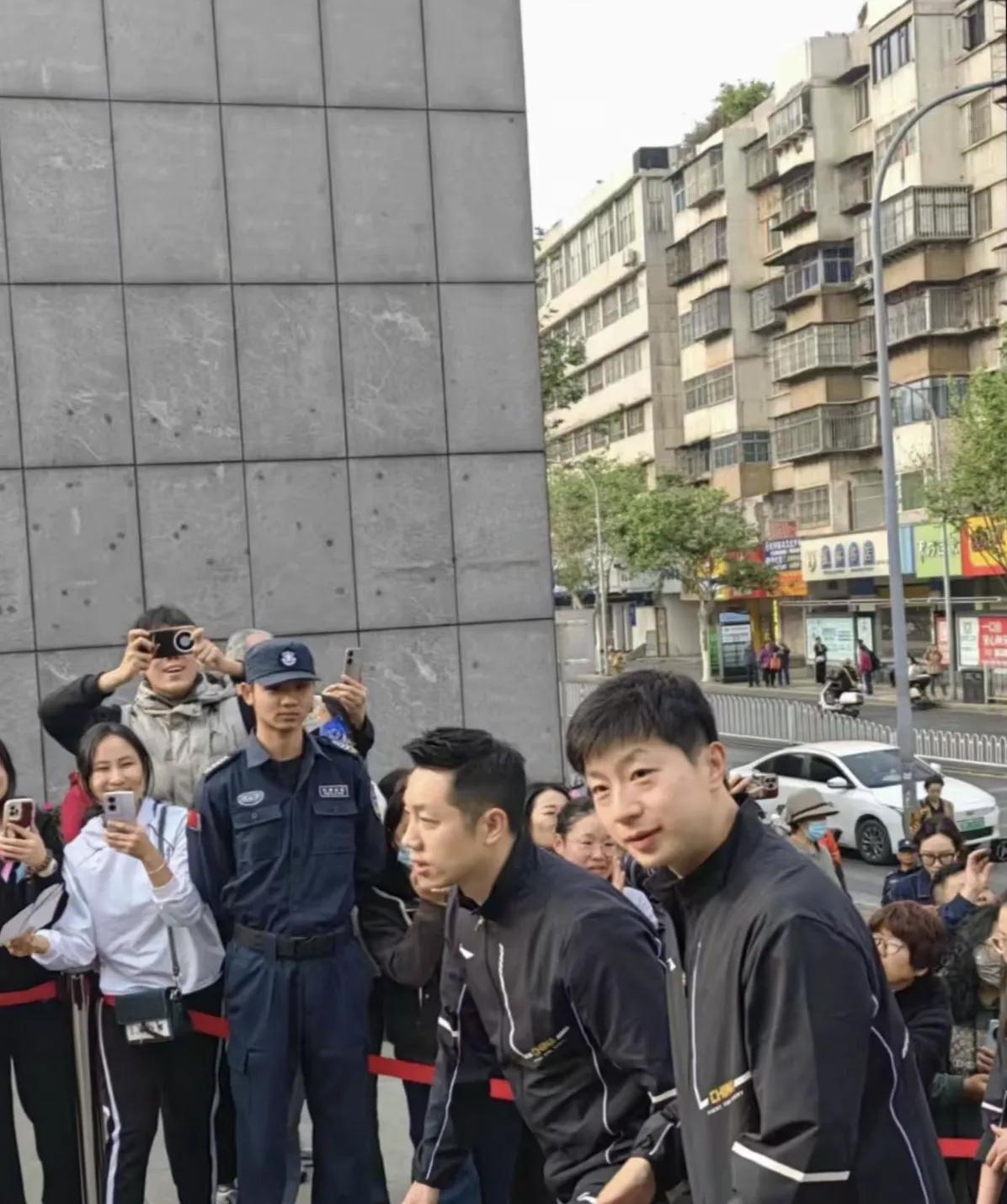 马龙、刘诗雯去云南师范大学呈贡校区。他们坐在旅游观光车内。周围围满了大学生。这些