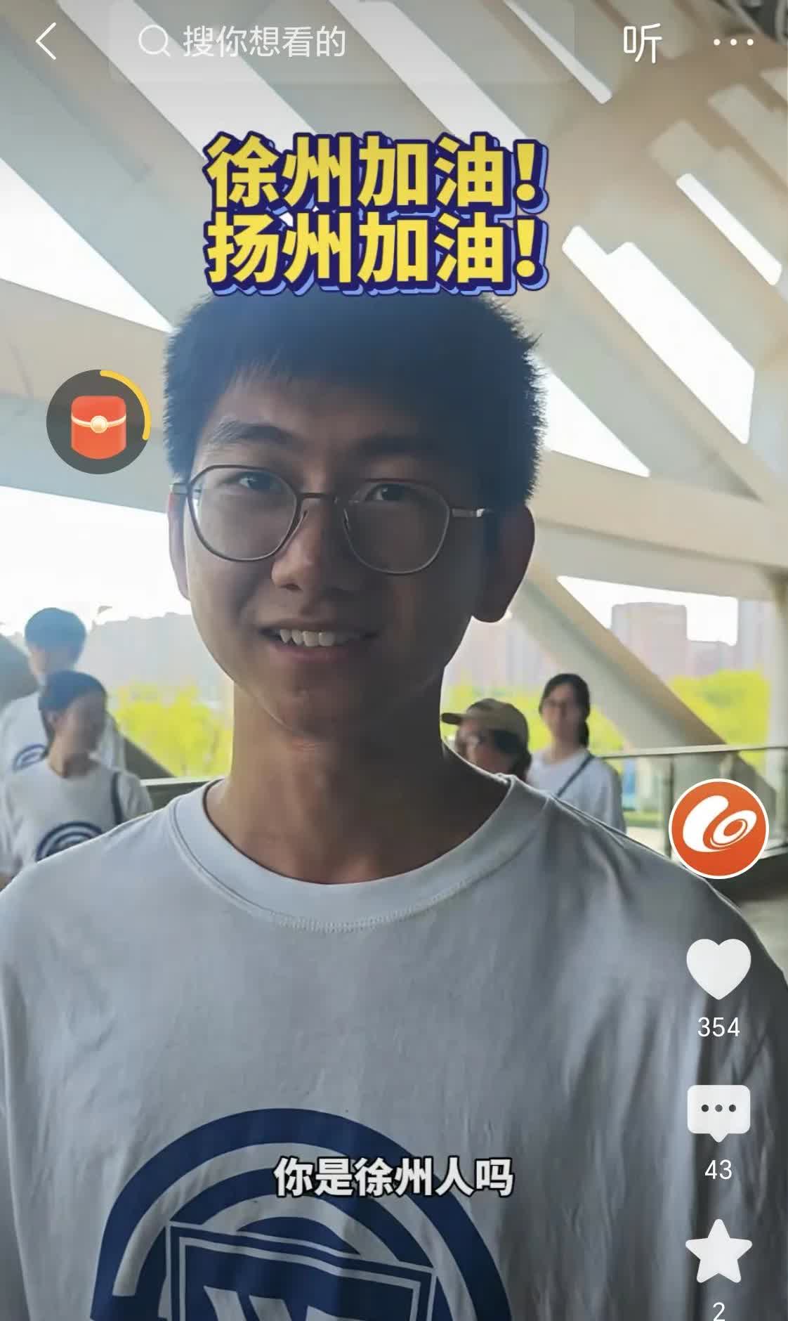 一个扬州小伙子在位于徐州的江苏师大上学并到徐州主场做志愿者，在徐州主场接受记者采