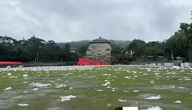 某大学毕业典礼大会之后的操场，白色垃圾遍地，白茫茫的一片，绿油油的草地披上了白大