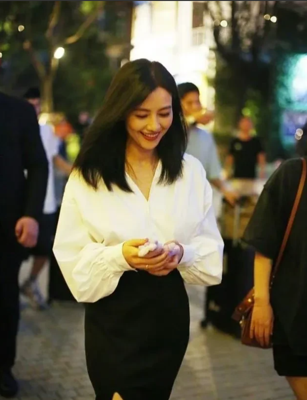 高圆圆也太美丽了吧，低头笑起来的样子让空气中都充满了浪漫的甜味，十分美好。白衬衫
