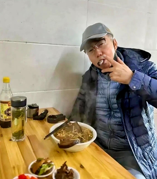照片中这位男明星老了竟如此接地气，独自坐在面馆大口吃面，配着几碟小菜，身边半个工