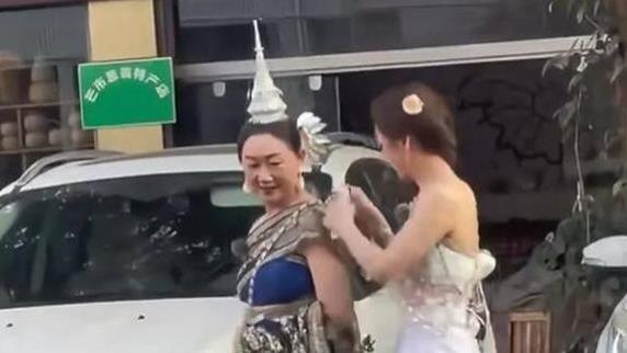 陈梦半露香肩和美背，身穿傣族服饰帮妈妈整理衣服，母女长相神似