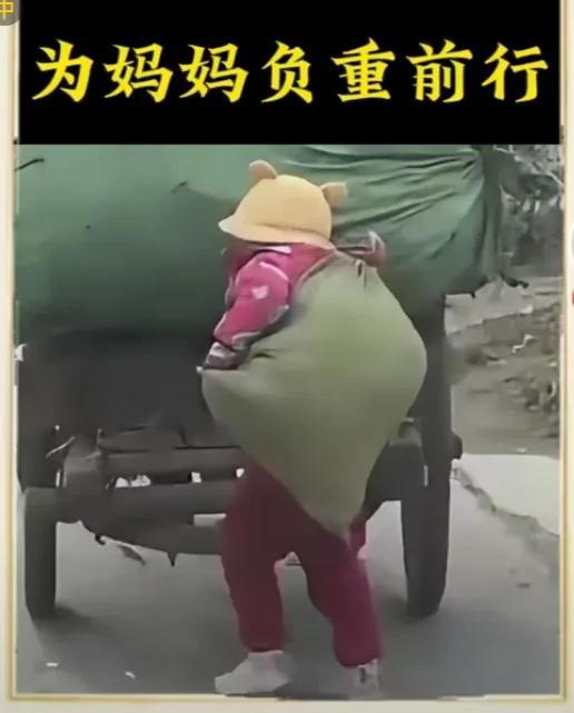 小小的身躯，为妈妈负重前行！看看这孩子，小小的身躯背了一大袋东西，还要腾出一只手