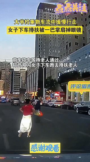 姑娘好心帮老人，却遭耳光相向。
一位老人颤颤巍巍地走在车流里，手中还提着沉甸甸的