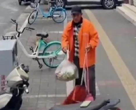 环卫工大爷正在打扫卫生，突然看到一辆电动车的车座上放了一部手机，他的眼睛一亮，做