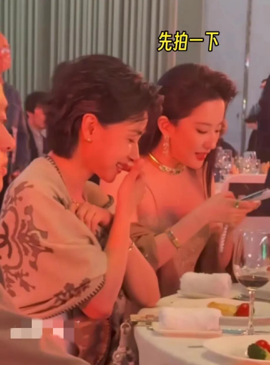 原来刘亦菲吃饭也是手机先吃，在白玉兰晚宴上，刘亦菲和万茜坐在一起，这时工作人员上