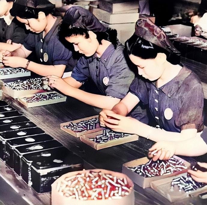 1941年9月，在日本的兵工厂里，一群女工正在认真地检查空弹壳有无瑕疵。二战期间