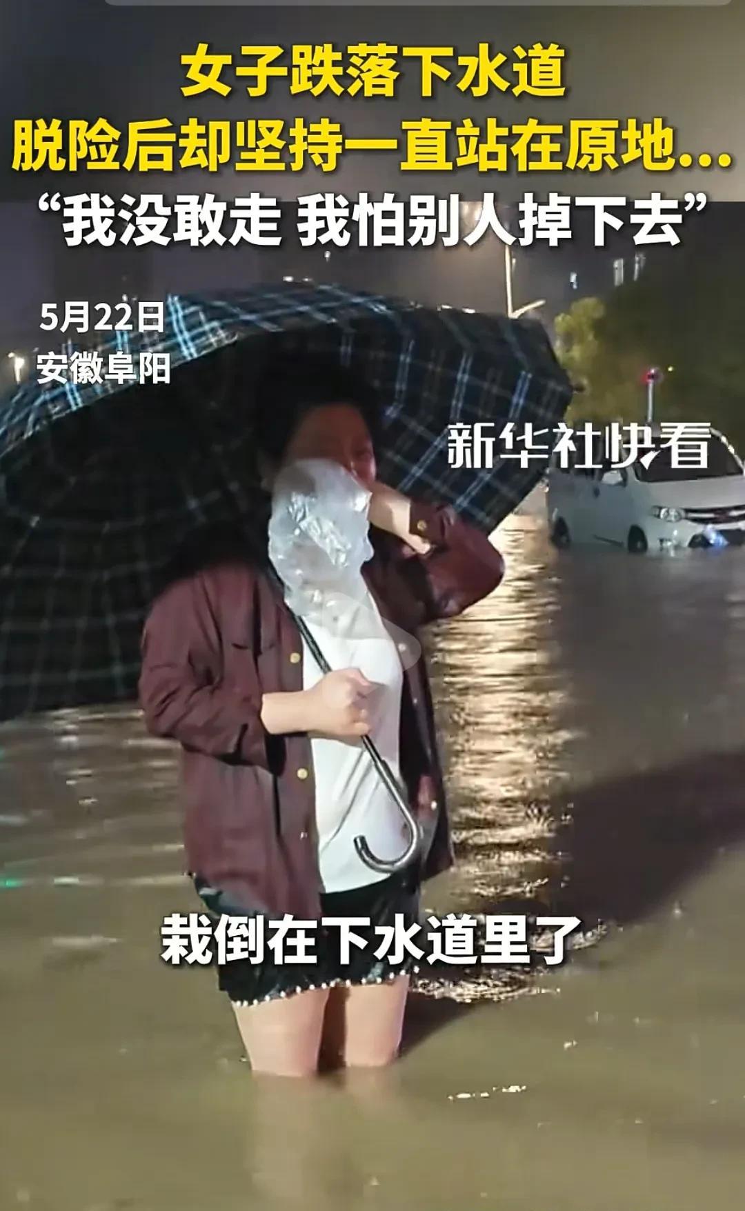 夜晚的阜阳街面积水成河，一名女子站在膝盖深的水里哭着说不敢离开，她刚跌入下水道被