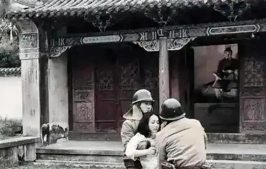 这是一张让华夏子孙热血沸腾、怒发冲冠的老照片。
两名小鬼子把一名妇女抬进了一座寺