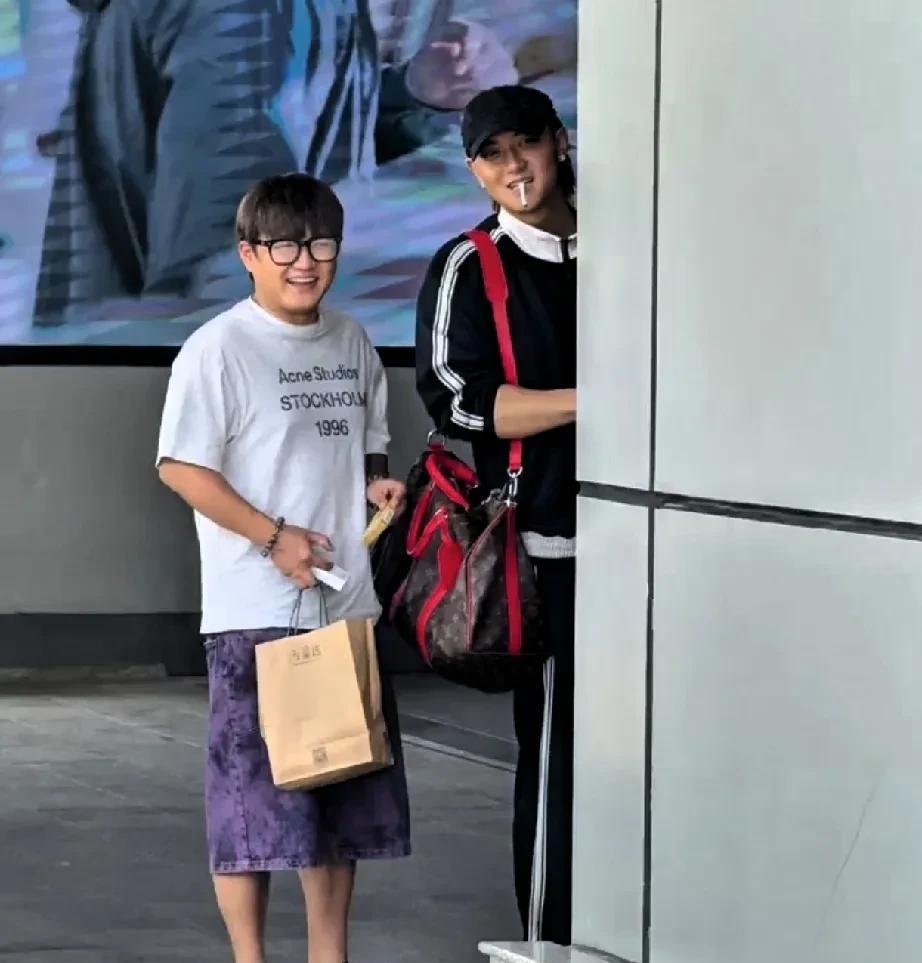 黄子韬烟瘾有点大，在机场外垃圾桶旁边大大方方抽烟，还时不时探出头，瞅瞅粉丝们啥情