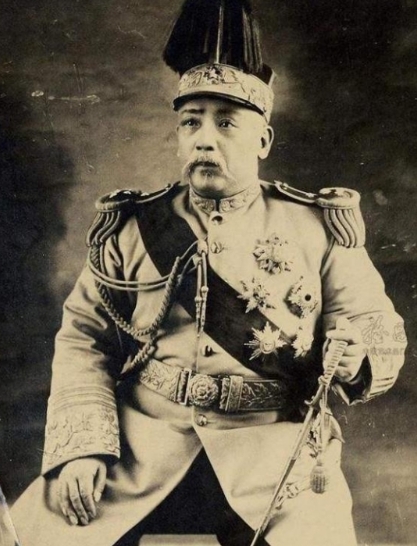 1915年，袁世凯正试穿龙袍，大姨太噗嗤一声笑了，袁世凯问：“笑什么？你一个风尘