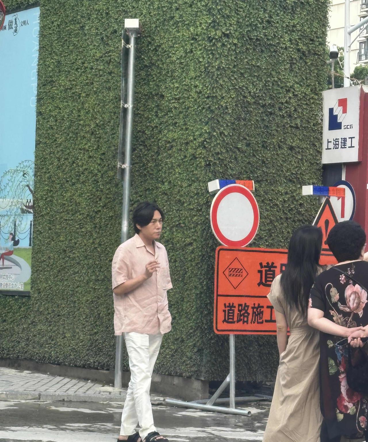 秦昊和伊能静带着公公婆婆出现在上海一处地产的施工处，秦昊穿着拖鞋，梳着中分，手上